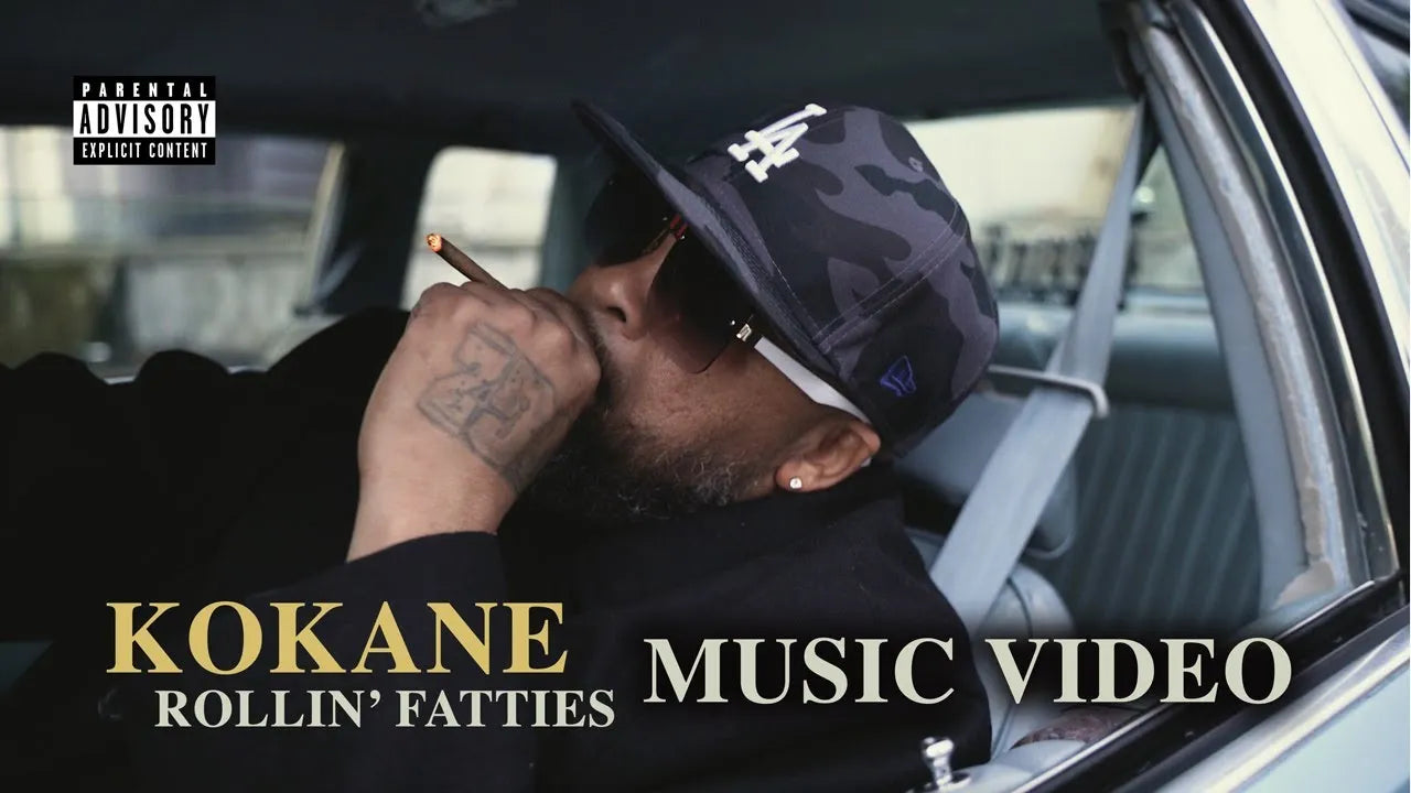 Kokane music video thumbnail. Artist in all black leaning in Cadillac with cigar. Text: Rollin' Fatties.